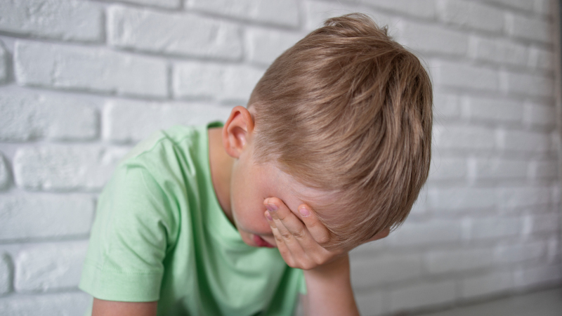 Мальчик закрыл руками лицо
