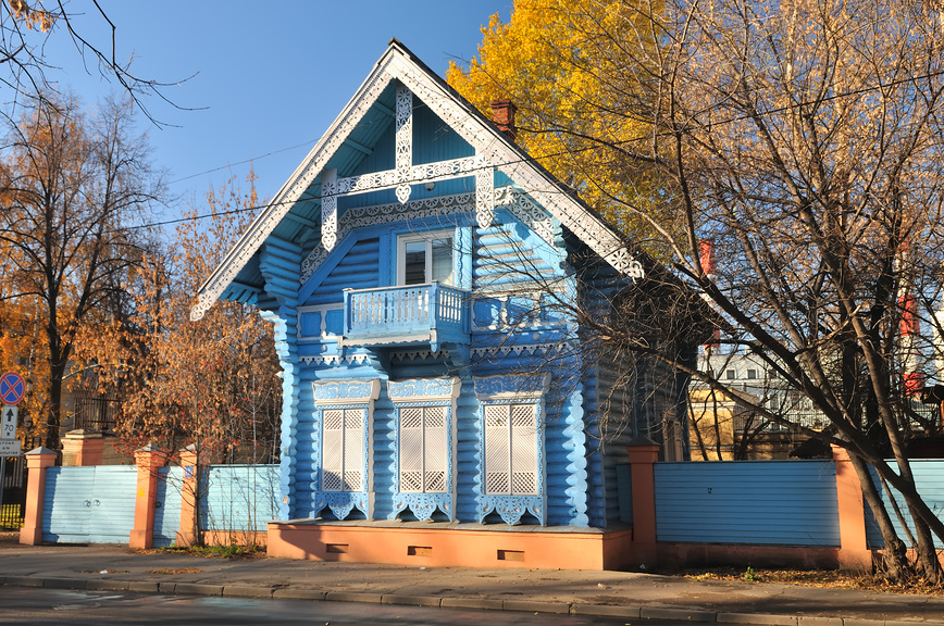 Деревянная изба, резные наличники, голубой сруб, осенний пейзаж, традиционная архитектура, резной балкон,