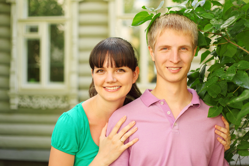 Молодая пара на фоне деревянного дома