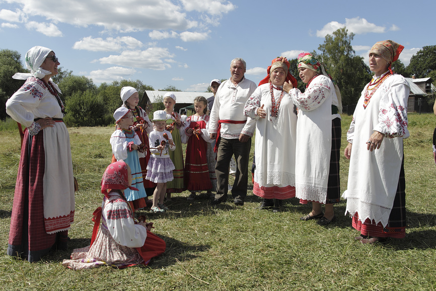 Народный фестиваль "Сенокос в Муранове".  Группа людей в народных костюмах поют народную песню на лугу