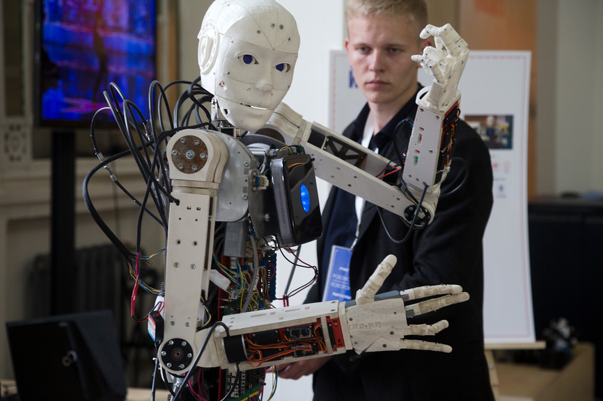 Молодой человек тестирует робота во время выставки «Робостанция» во втором павильоне (Павильон Образование) на ВДНХ в городе Москве, Россия (2015 год)