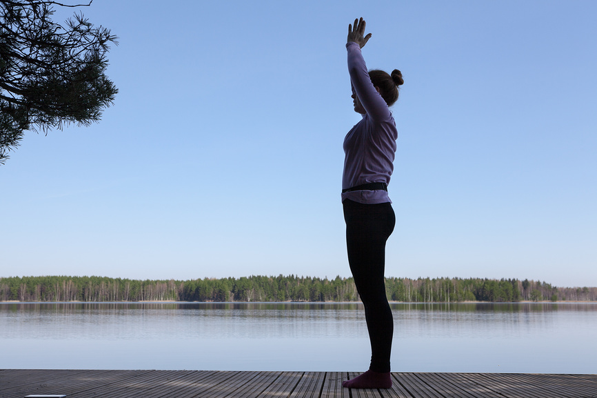 Дыхательные и расслабляющие упражнения на пирсе около озера