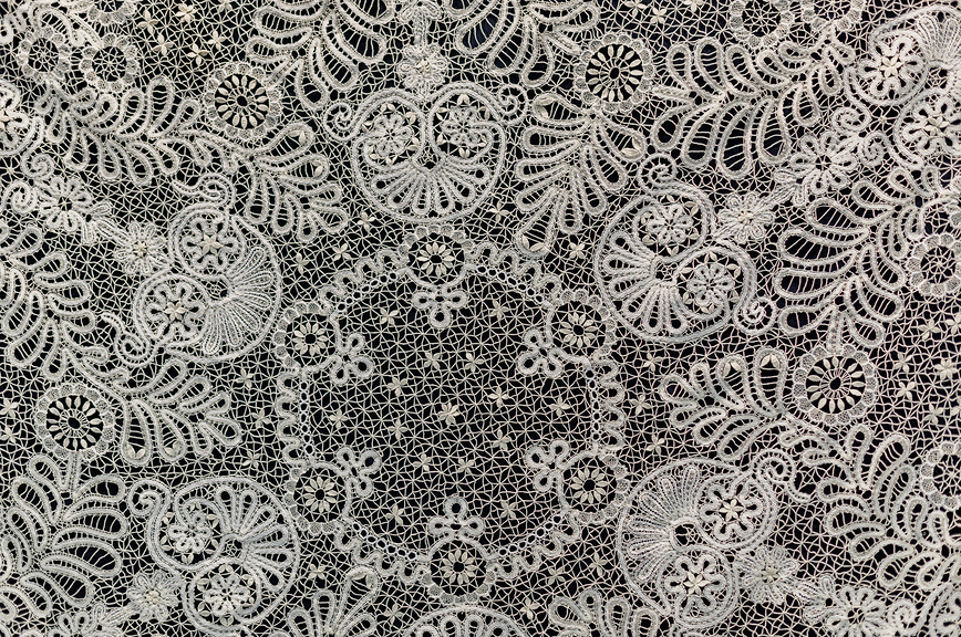 Ажурный фрагмент вологодского кружева на черном фоне