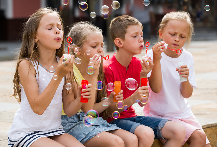 Дети пускают мыльные пузыри на улице