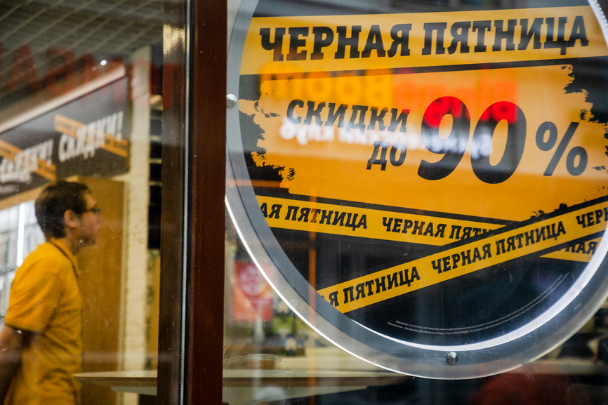 Рекламный плакат в витрине магазина в торговом центре с информацией о скидках в ежегодный день скидок "Черная пятница" в последнюю пятницу ноября в городе Москве