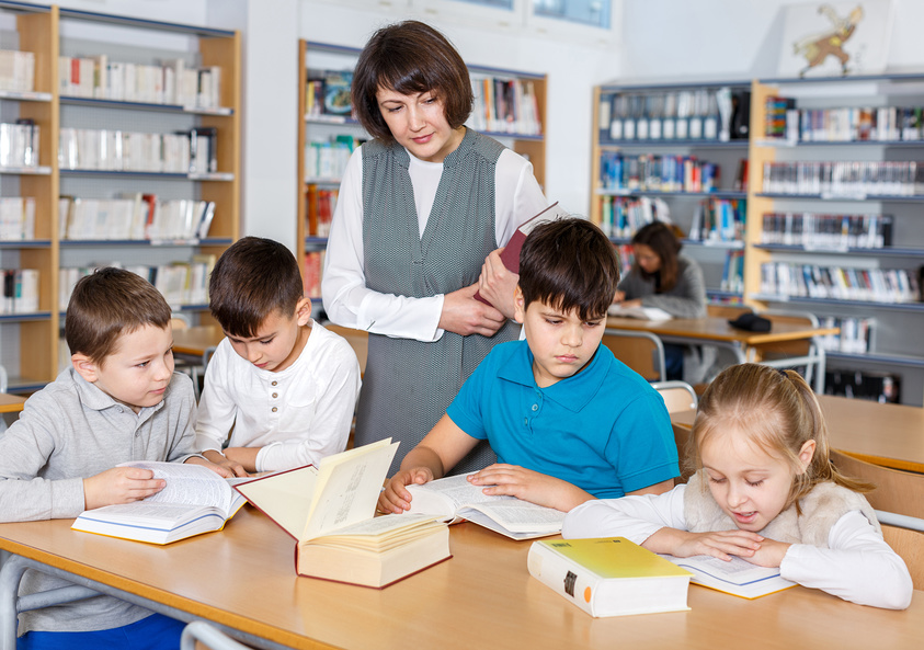 Учительница и ученики, работающие в классе