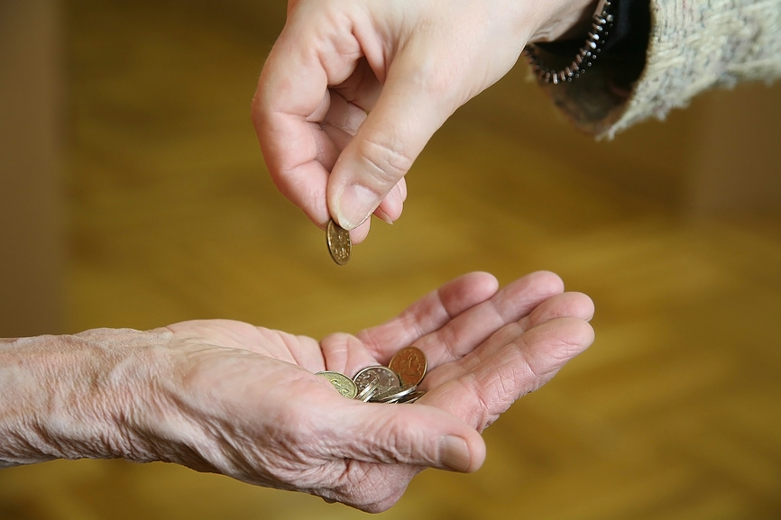 Женщина подает милостыню старой бедной женщине. Крупным планом