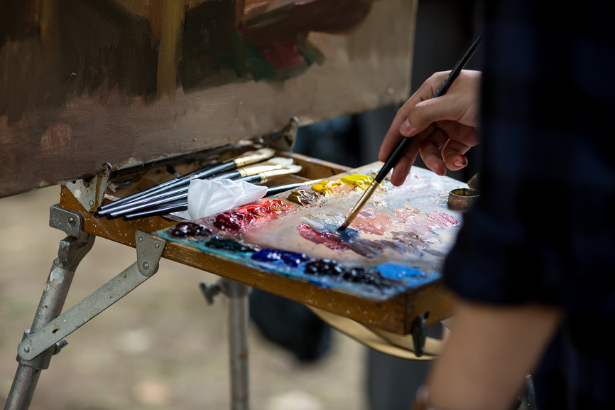 Россия. Ежегодный фестиваль в Москве "Времена и эпохи". Историческая реконструкция на чистых прудах в 2018 году. Художник рисует портрет женщины в средневековом наряде.