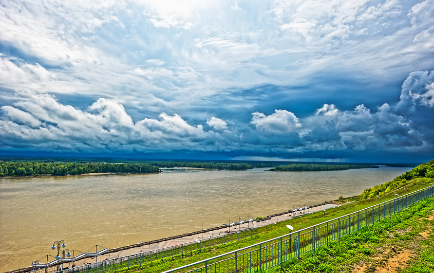 Вид на широкую реку с грозой на горизонте