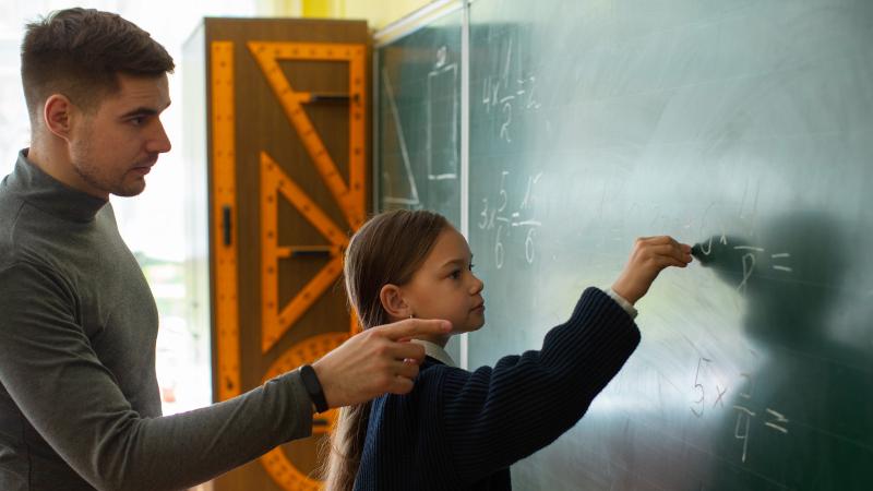 Девочка отвечает у доски в школе